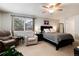 Bright main bedroom featuring plush seating, ceiling fan, and comfortable queen bed for a relaxing retreat at 8129 Locust Dr, Littleton, CO 80125