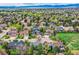 Stunning aerial showcasing homes surrounded by a vibrant green landscape and mountain views at 5305 W Lake Pl, Littleton, CO 80123