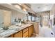 Primary bathroom featuring double sinks, granite counters, and separate tub and shower at 5305 W Lake Pl, Littleton, CO 80123