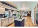 Bright kitchen with island, white cabinetry, quartz countertops, stainless appliances, and hardwood floors at 5305 W Lake Pl, Littleton, CO 80123