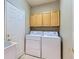 Functional laundry room equipped with a washer, dryer, and cabinets for storage, streamlining laundry tasks at 5305 W Lake Pl, Littleton, CO 80123