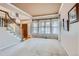 Open living room featuring carpet, staircase, and large windows with elegant curtains at 5305 W Lake Pl, Littleton, CO 80123