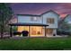 Beautiful backyard at twilight, featuring a covered patio with outdoor seating and a lush lawn, perfect for relaxation at 6488 Tilbury Ave, Firestone, CO 80504