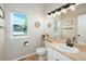 Bathroom featuring an oval sink, a large mirror, and a window overlooking the front yard at 6488 Tilbury Ave, Firestone, CO 80504