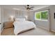 Cozy bedroom with a ceiling fan, bright window and light walls and furnishings at 6488 Tilbury Ave, Firestone, CO 80504
