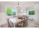 Bright dining room with modern light fixture, stylish furnishings, and large windows that bring in natural light at 6488 Tilbury Ave, Firestone, CO 80504