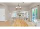 Open-concept dining area with hardwood floors, modern chandelier, and slider to the outdoor space at 6488 Tilbury Ave, Firestone, CO 80504