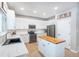 Modern kitchen featuring white cabinets, granite countertops, stainless steel appliances, and a wood-topped island at 6488 Tilbury Ave, Firestone, CO 80504