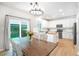 Bright kitchen with white cabinets, a central island, stainless steel appliances, and a sunny breakfast nook at 6488 Tilbury Ave, Firestone, CO 80504