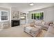 Bright living room with a modern fireplace, built-in shelving, comfortable seating, and ample natural light at 6488 Tilbury Ave, Firestone, CO 80504