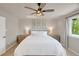 Comfortable bedroom with a ceiling fan, bright window and light walls and furnishings at 6488 Tilbury Ave, Firestone, CO 80504