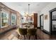 Charming dining room features exposed brick walls, modern chandelier, and views into the kitchen at 1053 S Washington St, Denver, CO 80209