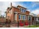 Charming brick home featuring a classic design with a welcoming front porch and a well-maintained front yard at 1053 S Washington St, Denver, CO 80209