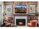 Close-up of a fireplace with a brick surround, flanked by bookshelves, and windows that frame a beautiful mountain view at 1053 S Washington St, Denver, CO 80209