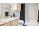 Well-lit bathroom with granite countertop, cabinet, and tiled tub with shower at 13782 E Lehigh Ave # B, Aurora, CO 80014