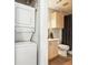 Compact bathroom with stackable washer/dryer and tiled tub with shower at 13782 E Lehigh Ave # B, Aurora, CO 80014