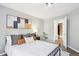 Stylish bedroom with a cozy bed, contemporary art, and an open bathroom entrance at 13782 E Lehigh Ave # B, Aurora, CO 80014