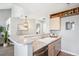 Kitchen with breakfast bar, stainless steel dishwasher and a view into the living room at 13782 E Lehigh Ave # B, Aurora, CO 80014