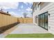 Large concrete patio with a wooden fence and sliding glass doors leading into the house at 3890 N Cook St, Denver, CO 80205