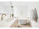 A modern bathroom featuring double sinks, a standalone soaking tub and sleek gold hardware at 3890 N Cook St, Denver, CO 80205