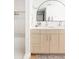 A bathroom featuring double sink vanity with light wood cabinets and a large arched mirror at 3890 N Cook St, Denver, CO 80205