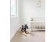 Charming Bedroom featuring a white crib, rocking moose, neutral colors, and natural light from the window at 3890 N Cook St, Denver, CO 80205