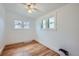 Bright bedroom featuring hardwood floors, white walls, and natural light from multiple windows at 4556 Decatur St, Denver, CO 80211