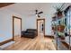 Comfortable living room with hardwood floors, a leather couch, and shelving for plants at 4556 Decatur St, Denver, CO 80211