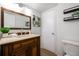 Bathroom features a wooden vanity, decorative shelves, and updated fixtures at 9042 E Lehigh Ave, Denver, CO 80237