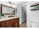 Bathroom featuring a wooden vanity, decorative shelves, and a toilet at 9042 E Lehigh Ave, Denver, CO 80237