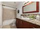 Well-lit bathroom with wood cabinets, granite countertops, shower and bath tub at 9042 E Lehigh Ave, Denver, CO 80237