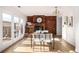 Bright dining area with a brick fireplace, modern table, and natural light at 9042 E Lehigh Ave, Denver, CO 80237