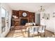 Charming dining room with a brick accent wall, wood table, and elegant lighting at 9042 E Lehigh Ave, Denver, CO 80237