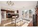 Bright kitchen and dining area with hardwood floors, stainless steel appliances, and brick fireplace at 9042 E Lehigh Ave, Denver, CO 80237