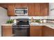 Close up of kitchen featuring stainless steel appliances, wood cabinets, and granite countertops at 9042 E Lehigh Ave, Denver, CO 80237