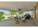 Relax on the covered patio with a ceiling fan, table, chairs, and a grill overlooking the beautiful lake at 293 Wagonwheel Dr, Fort Lupton, CO 80621
