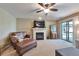 Inviting living room with fireplace, arm chair, ottoman and sliding door access to outdoor space at 293 Wagonwheel Dr, Fort Lupton, CO 80621
