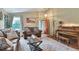 Comfortable living room featuring a leather sofa, a piano, and an entrance with a window showcasing natural light at 293 Wagonwheel Dr, Fort Lupton, CO 80621