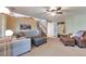 Cozy living room with large sectional sofa, ceiling fan, and stairs leading to the upper level at 293 Wagonwheel Dr, Fort Lupton, CO 80621