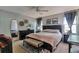 Spacious main bedroom with a ceiling fan, a bench at the foot of the bed, and soft natural light at 293 Wagonwheel Dr, Fort Lupton, CO 80621