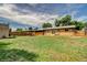 Large backyard with a well-maintained lawn, privacy fence, and outdoor seating area at 8418 Ames, Arvada, CO 80003