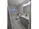 Updated bathroom with gray vanity, matching cabinets, and tiled shower over tub at 8418 Ames, Arvada, CO 80003