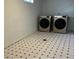 Functional laundry room with modern washer and dryer appliances and black and white tile flooring at 8418 Ames, Arvada, CO 80003