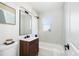 Bathroom features wood vanity with double sinks, updated fixtures, and bright window at 2295 S Sherman St, Denver, CO 80210