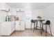 Kitchenette with white cabinets, updated fixtures, and counter seating for two at 2295 S Sherman St, Denver, CO 80210