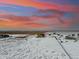 Aerial view of the ranch home with sprawling acreage and colorful sunset at 39200 E 148Th Ct, Keenesburg, CO 80643