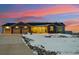 Charming ranch style home with stone accents, a three car garage, and a cozy front porch at sunset at 39200 E 148Th Ct, Keenesburg, CO 80643