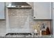 Modern kitchen backsplash featuring granite countertops, gas range, and stainless steel exhaust hood at 39200 E 148Th Ct, Keenesburg, CO 80643