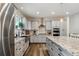 Spacious kitchen with stainless steel appliances, gray cabinets, granite counters, and wood floors at 39200 E 148Th Ct, Keenesburg, CO 80643