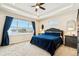 Tranquil bedroom with tray ceiling, large window with blue curtains, and modern furniture at 39200 E 148Th Ct, Keenesburg, CO 80643